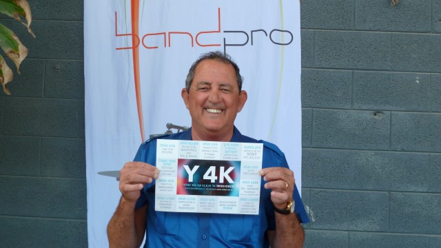 Band Pro President, Amnon Band holding a "Y4K" flyer outside of the exhibition. 